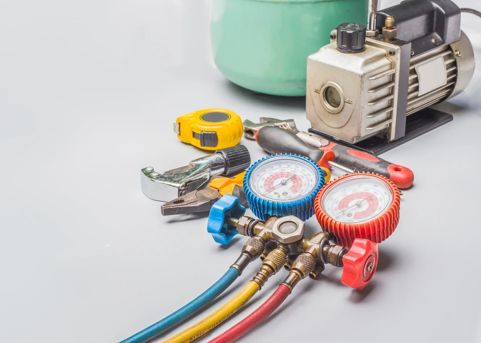 Un artisan ou équipe d'artisans dans un intérieur résidentiel montrant plusieurs corps de métier simultanément : un technicien manipulant des installations sanitaires (tuyauterie, radiateur ou thermostat) visibles dans la même scène que des éléments électriques (tableau électrique ou points de répartition) ou du matériel de chauffage. La scène doit transmettre l'idée d'une prise en charge globale multi-technique. Qualité photo professionnelle, contexte résidentiel ou semi-commercial, lumière naturelle, l'artisan en tenue de travail appropriée.